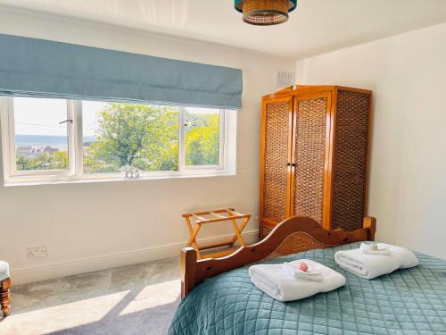 - une chambre avec un lit et 2 serviettes dans l'établissement Gordy Hall -Sea facing Welsh cottage with stunning views, à Pendine