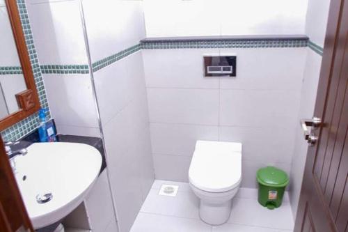 een witte badkamer met een toilet en een wastafel bij TULIA BEACH HOUSE, AT SULTAN PALACE in Kilifi
