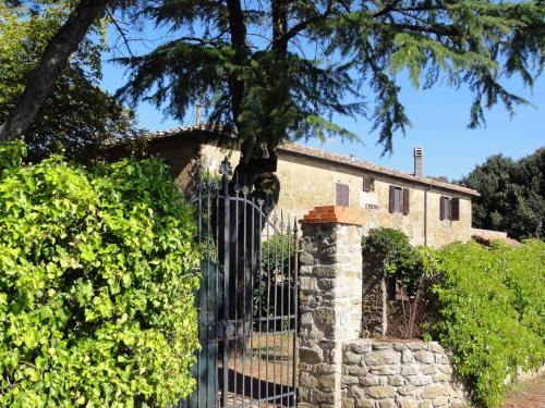 a gate in front of a house with a tree at Castello del Calcione in Lucignano