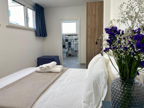 a bedroom with a bed with a vase of flowers at Sperlonga Center Holiday in Sperlonga