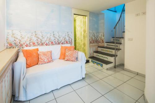 a living room with a white couch with orange pillows at Luxurious apartment by the sea in Vietri sul Mare