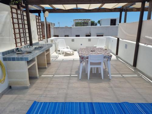 a patio with a table and chairs on a roof at CASA TURCHESE in Favignana