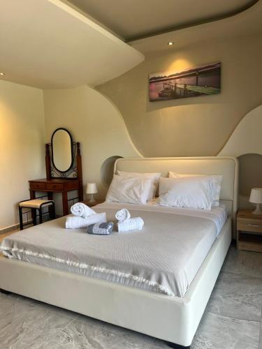 a bedroom with a white bed with towels on it at Suites Ris in Néa Péramos