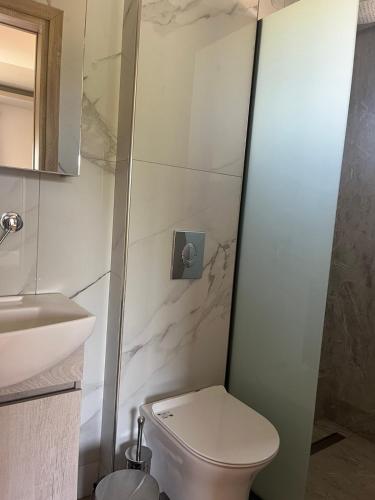 a bathroom with a toilet and a sink at Suites Ris in Néa Péramos