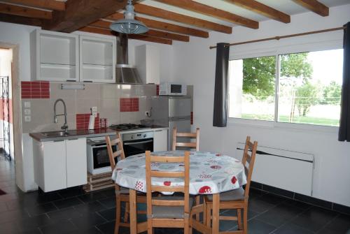 une cuisine avec une table et des chaises dans une pièce dans l'établissement La Tour, à Rouffignac