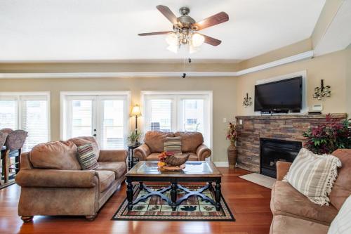 a living room with a ceiling fan and a fireplace at Skyline Sanctuary Wrap Around Deck in Gatlinburg