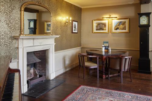 a dining room with a table and a fireplace at Bell by Greene King Inns in Thetford