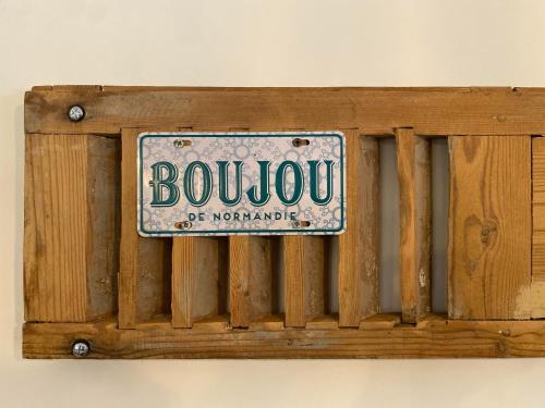 a wooden sign on a wall with a sign on it at Maison La folie douce in Saint-Pierre-de-Manneville