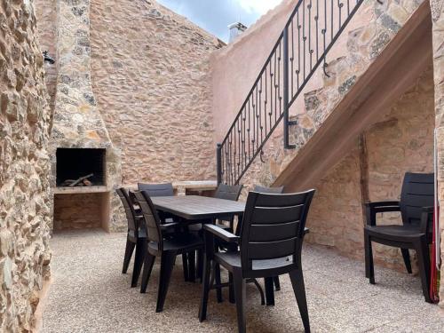 a table and chairs on a patio with a brick wall at El Descanso del Talegones in Torrevicente