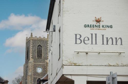 a sign on the side of a building with a clock tower at Bell by Greene King Inns in Thetford