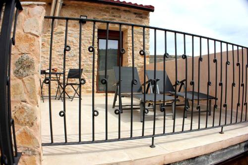a metal railing on a balcony with a table and chairs at El Descanso del Talegones in Torrevicente