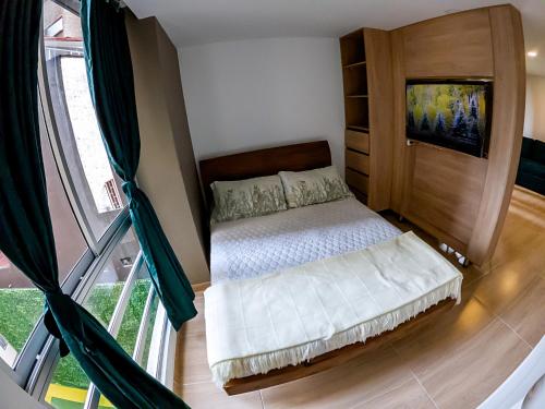 a bedroom with a bed and a large window at Cómodo apartamento tipo Loft en centro de Bogotá 5 in Bogotá