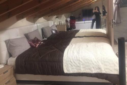 a woman taking a picture of a bed in a room at 1 bedroom loft at Mytilene Port in Mytilini