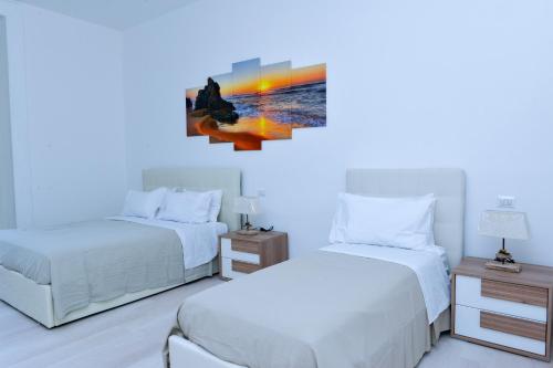 a bedroom with two beds and a painting on the wall at L'Aurora Azzurra -Luxury Suites Sorrento coast in Piano di Sorrento