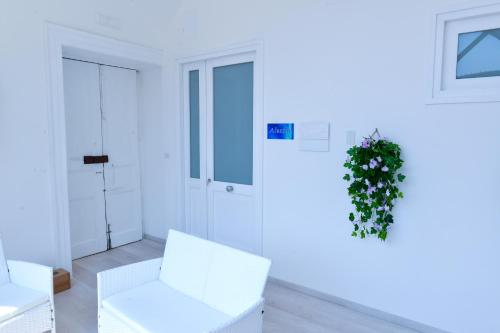 a white room with white chairs and a plant at L'Aurora Azzurra -Luxury Suites Sorrento coast in Piano di Sorrento