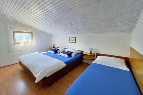 a bedroom with two beds with blue and white sheets at Apartments Srdoc in Šilo
