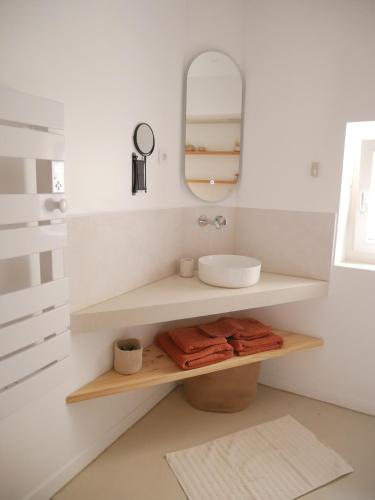 une salle de bain avec un lavabo et un miroir dans l'établissement Le Clos des Confidences, à Grignan