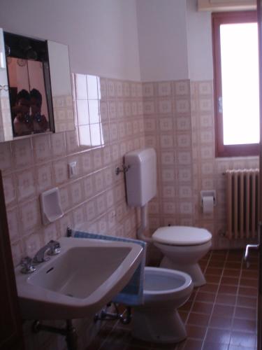a bathroom with a sink and a toilet and a mirror at Appartamento Colombo in Cassina Valsassina