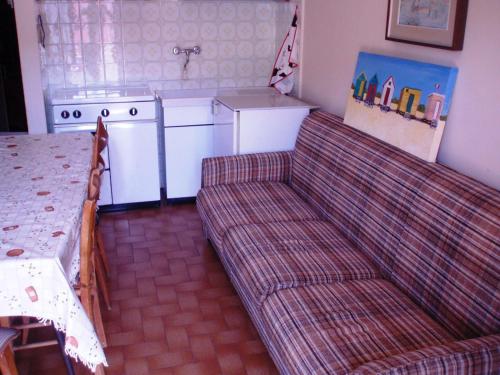 sala de estar con sofá y cocina en Appartamento Colombo, en Cassina Valsassina