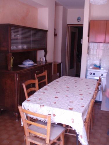 una mesa y sillas en una cocina con mesa, mesa y mesa en Appartamento Colombo, en Cassina Valsassina
