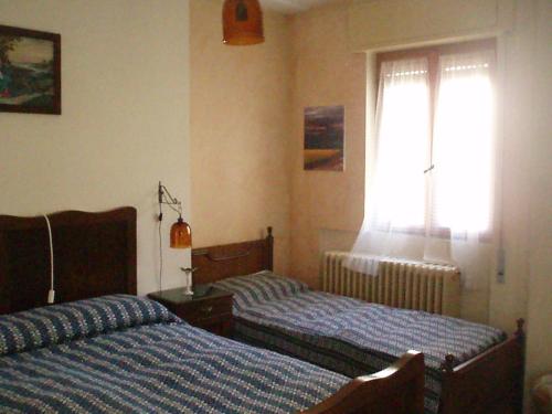 Un dormitorio con 2 camas y una ventana con en Appartamento Colombo, en Cassina Valsassina