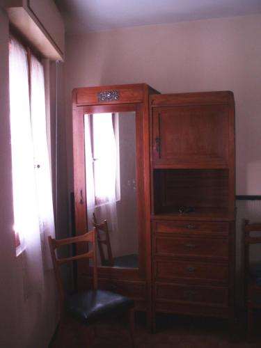 Cassina ValsassinaにあるAppartamento Colomboの木製のキャビネットと窓が備わる客室です。