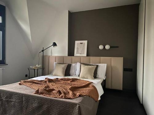 a bedroom with a bed with a brown blanket on it at Bielawy Suite in Bydgoszcz