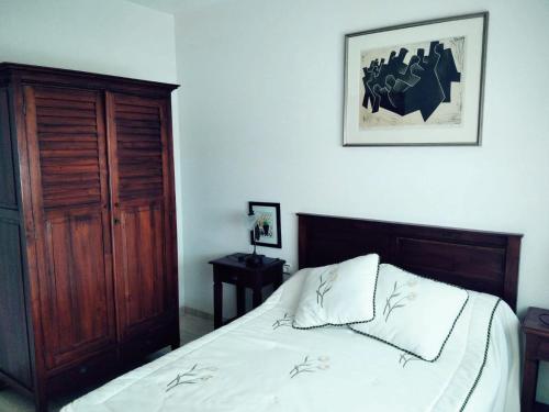 1 dormitorio con 1 cama y una foto en la pared en Homely Apartments Blue Coast, en San Miguel de Salinas