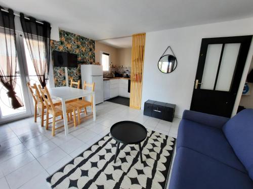 un salon avec un canapé bleu et une table dans l'établissement Coeur Marina climatisé terrasse parking, à Fréjus