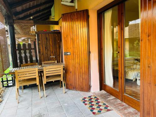 a patio with a table and chairs and a glass door at Borgo del Nibbio in Porto Levante