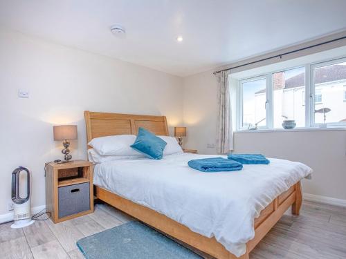 a bedroom with a bed with blue pillows on it at Riverside Apartment in Bideford