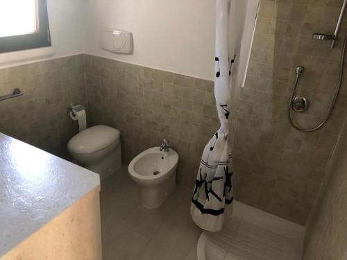 a bathroom with a shower and a toilet and a sink at Casa Vacanza Budoni Mare in Budoni