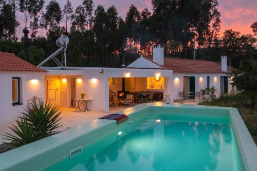 a villa with a swimming pool in front of a house at Monte Esmeralda in São Luis