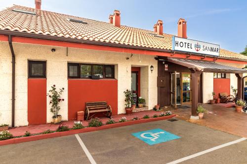 a hotel with a parking lot in front of a building at Hotel SanMar in Cóbreces