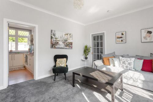 a living room with a couch and a table at Lovely 3bed House-Private parking in Edinburgh