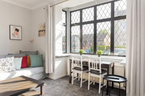 Lovely 3bed House-Private parking في إدنبرة: غرفة معيشة مع أريكة وطاولة ونافذة