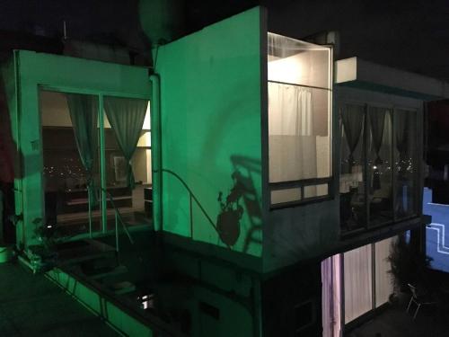 a house with a green wall and a window at Loft en Tercer Piso con Vista Panoramica in Puebla