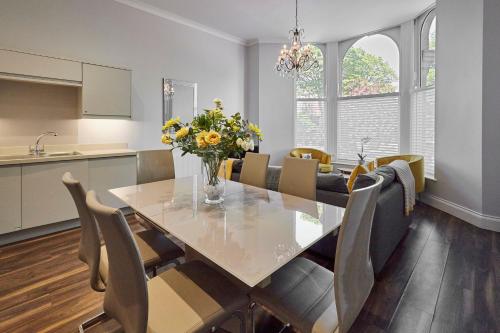 a kitchen and dining room with a table and flowers at Host & Stay - Brooklands Timeless in Scarborough