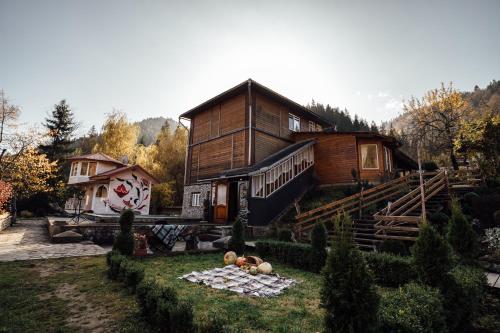 a house with a garden in front of it at Хата Різьбяра - Закуток in Beloberëzka