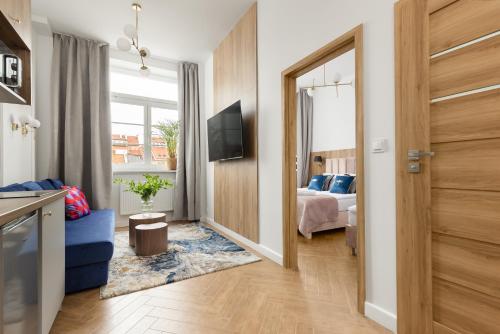 Movo II Old Town Apartments في وارسو: غرفة معيشة مع أريكة زرقاء وسرير