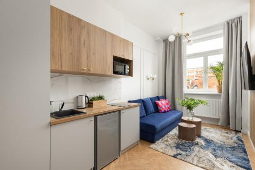 a kitchen with a blue couch in a room at Movo II Old Town Apartments in Warsaw