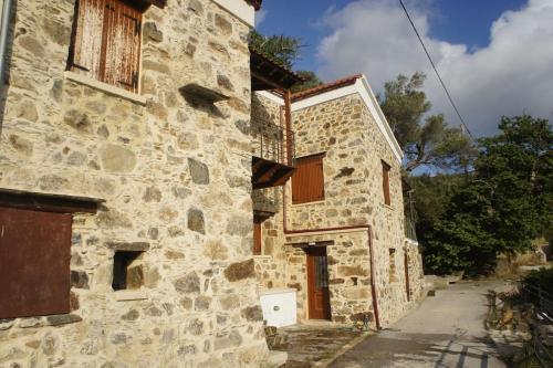 un antiguo edificio de piedra con una puerta en una calle en Rosales stone house, en AmigdhalokeFálion