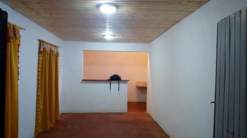 a hallway with white walls and a table and yellow curtains at BELLA CASA EN VILLA LIBERTAD in Leandro N. Alem