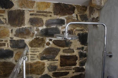a stone wall with a shower in a bathroom at Rosales stone house in AmigdhalokeFálion