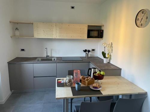 a kitchen with a table and a clock on the wall at Casetta Mary in Bellagio