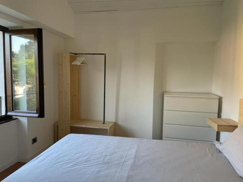 a bedroom with a white bed and a window at Casetta Mary in Bellagio