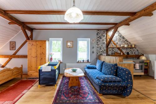 a living room with a blue couch and a table at Agroturystyka Ziemia Obiecana in Nielestno