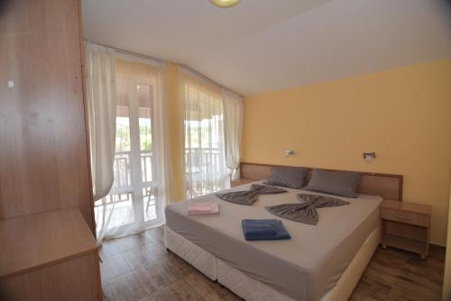 a bedroom with a bed and a large window at Villa Raya in Sozopol