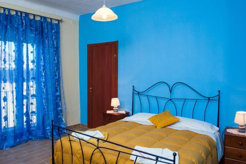 a blue bedroom with a bed with a blue wall at Umberto 33 in Piazza Armerina