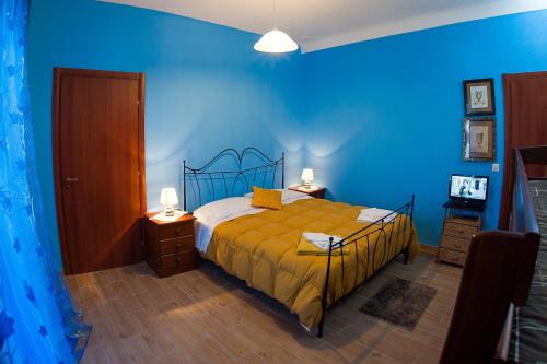 een blauwe slaapkamer met een bed en een blauwe muur bij Umberto 33 in Piazza Armerina